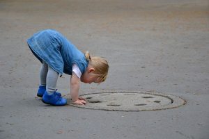 Mädchen und Schachtdeckel