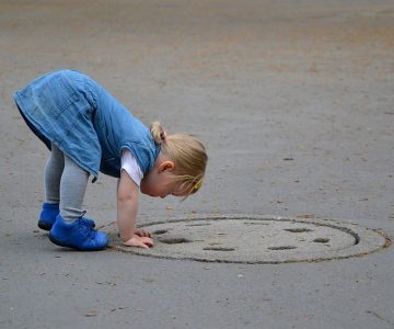 Mädchen und Schachtdeckel