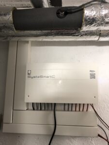 Heizungsregler SystaSmartC mit Volumenstromsensor im Rücklauf des Peleo Optima, getrennte Kabelkanäl für Signalleitungen und stromführende Kabel