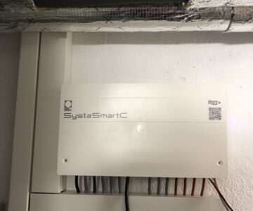 Heizungsregler SystaSmartC mit Volumenstromsensor im Rücklauf des Peleo Optima, getrennte Kabelkanäl für Signalleitungen und stromführende Kabel